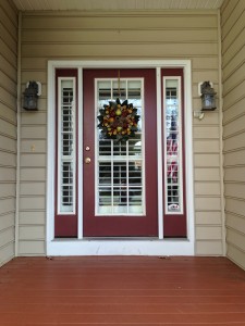 Front view of house of custom door shutters on red door