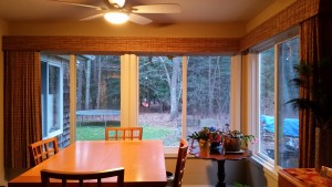 Dining room with table and vertical treatments open curtains outside view