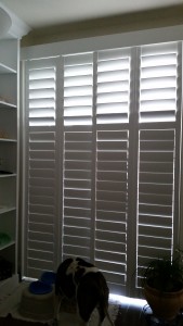 Front view of custom shutters on a large sliding glass door
